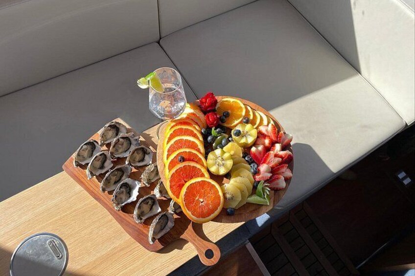 A wooden cutting board with sliced oranges, strawberries, blueberries, kiwi, and a whole orange. 3