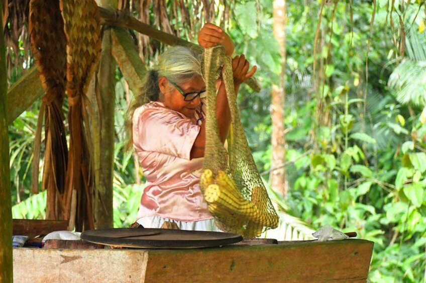 A person handling a large, woven basket in a forested area. 3