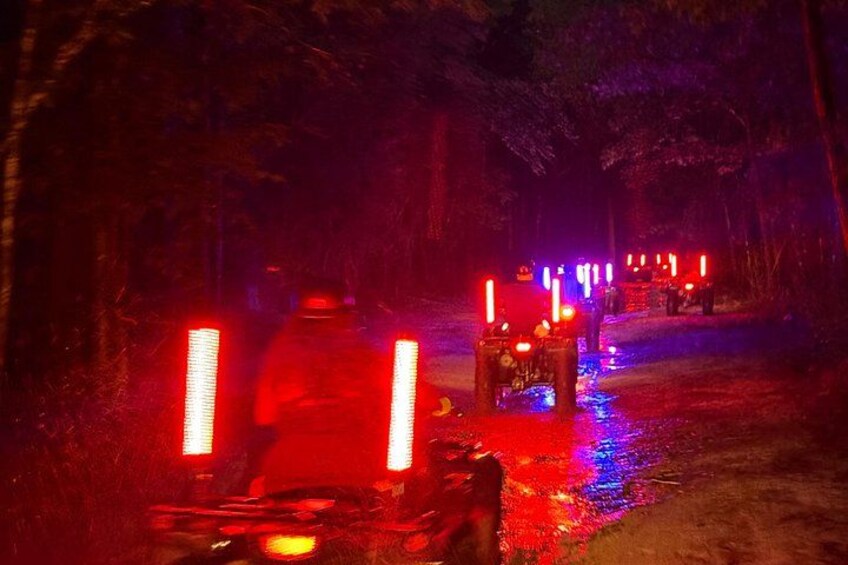 A nighttime scene with illuminated objects and a path through a forest. 3