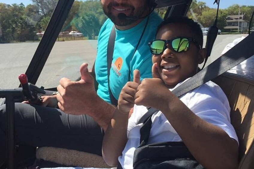 A person in a vehicle with a steering wheel and a seatbelt. 3