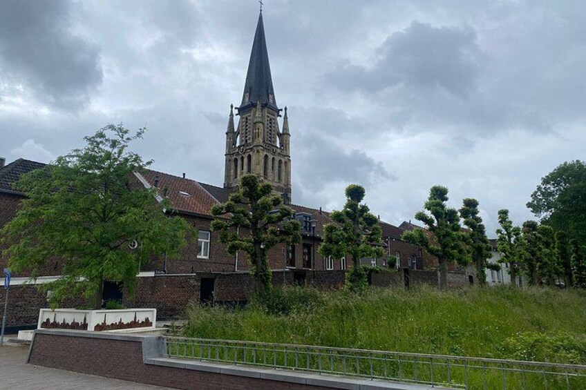 A church with a tall spire, surrounded by residential buildings and greenery. 5