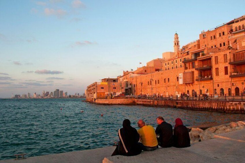 A waterfront with buildings, a pier, and a city skyline in the background. 2