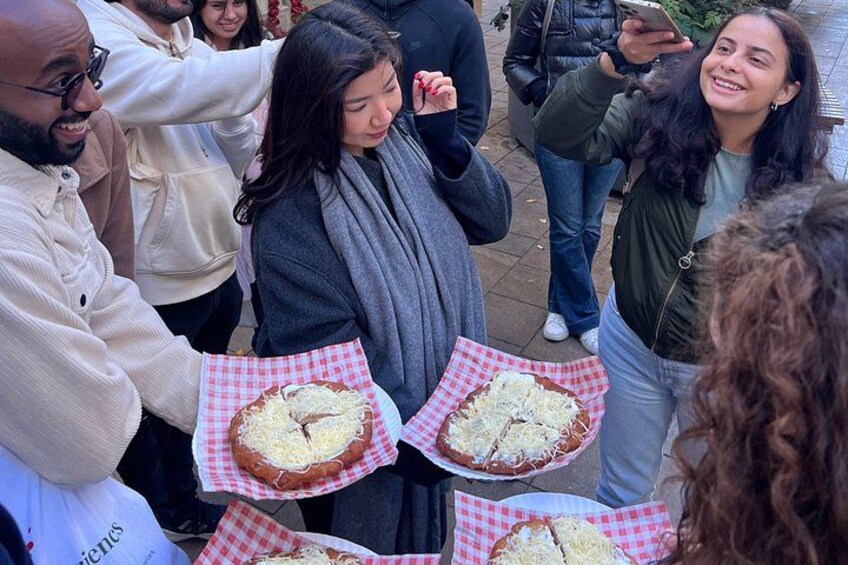 People holding food items on checkered paper. 2