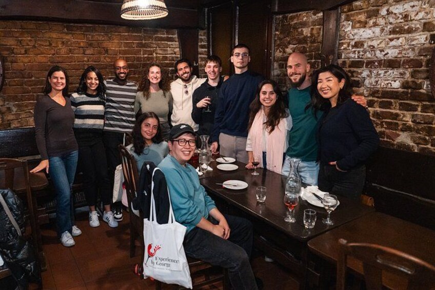 A group of people seated at a table in a brick-walled restaurant. 3