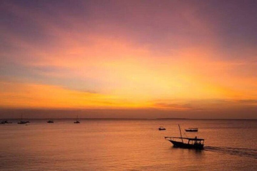 A calm sea at sunset with several boats. 2