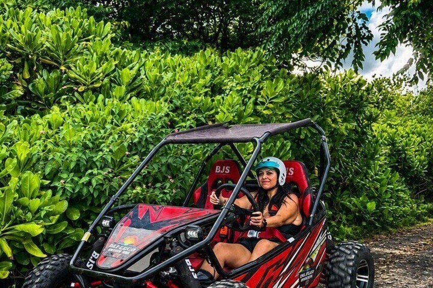 A person in a red off-road vehicle with 'BIS' branding, driving through a lush green area. 3