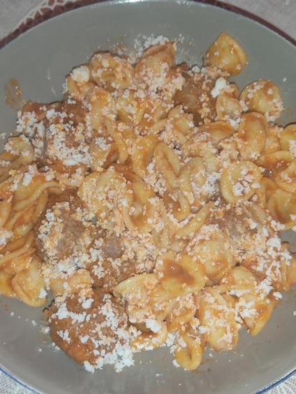 A plate of pasta with a tomato-based sauce and grated cheese. 2