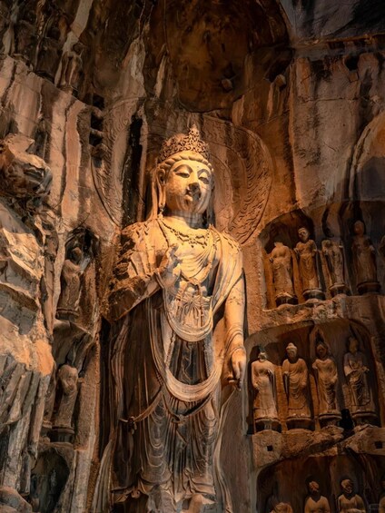 A large Buddha statue in a cave with smaller statues around it. 3