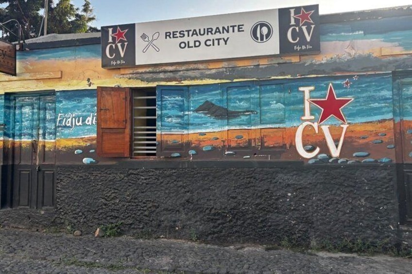 A building with a mural of a beach scene and a sign for 'Restaurante Old City.' 3