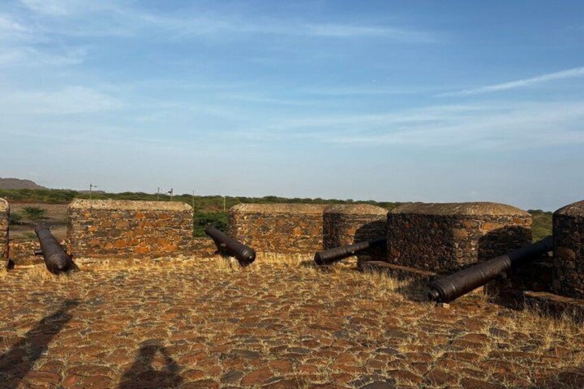 A historical fort with cannons, stone walls, and a clear sky. 4