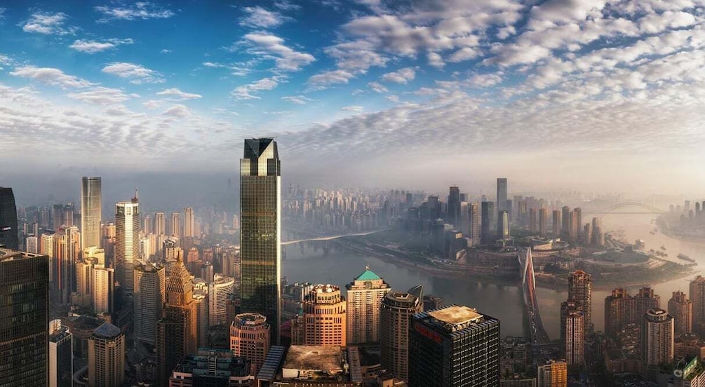 A cityscape with modern skyscrapers, a river, and a bridge. 4