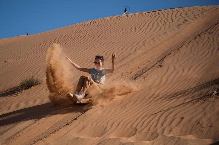 A person sliding down a sand dune. 2
