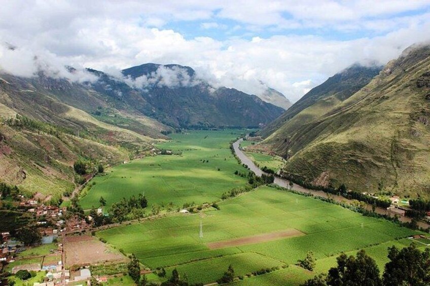 A valley with a river, green fields, and mountains. 2
