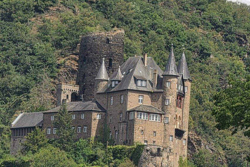 A castle on a hill with multiple towers and a moat. 4