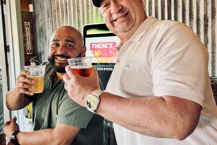 Two people holding drinks in front of a counter with a sign that reads 'THERE'S NO'. 3