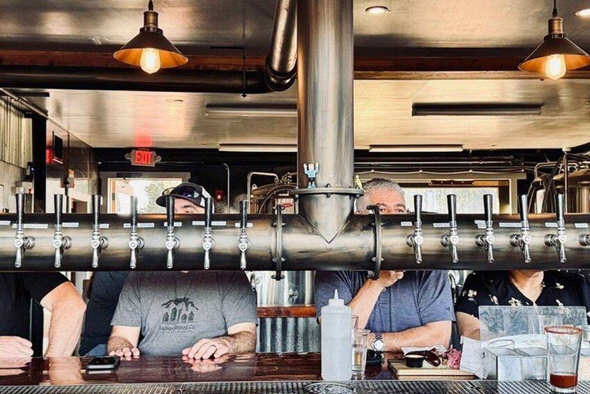 A bar with multiple taps and a person pouring a drink. 5