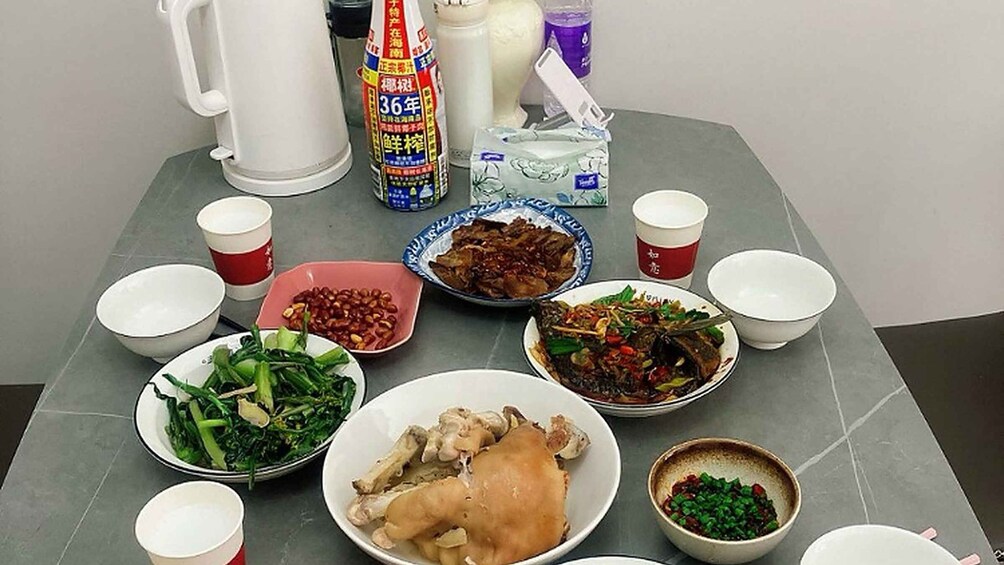 A table with various dishes, cups, and a bottle of soy sauce. 4