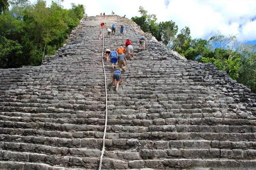 A group of people climbing a large stone staircase. 1