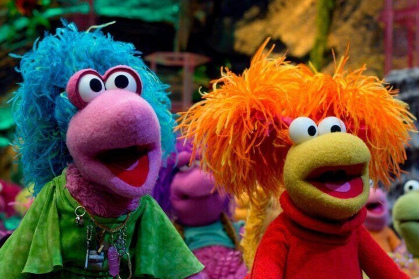 A group of colorful puppet characters with distinct hair colors and accessories. 5