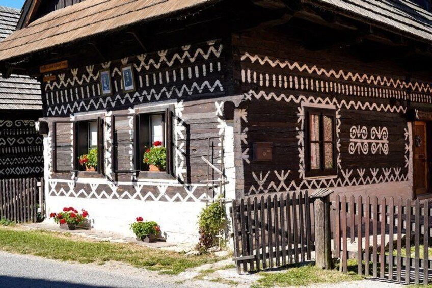 A traditional wooden house with decorative patterns and flower boxes. 2