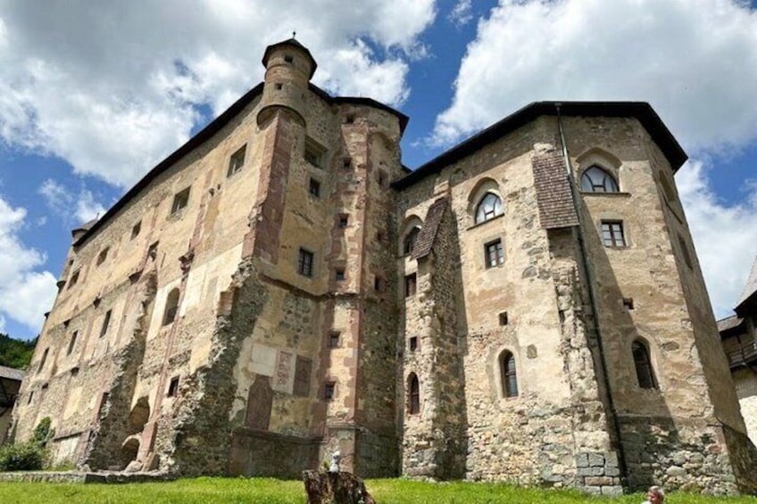 A historic stone building with arched windows and a turret. 2
