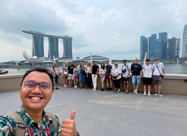 A group of people posing for a photo with a city skyline and a bridge in the background. 1