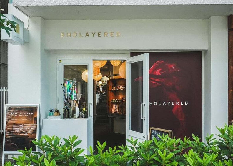 A storefront with the name 'SHOLAYERED' and a large poster of a red flower. 5