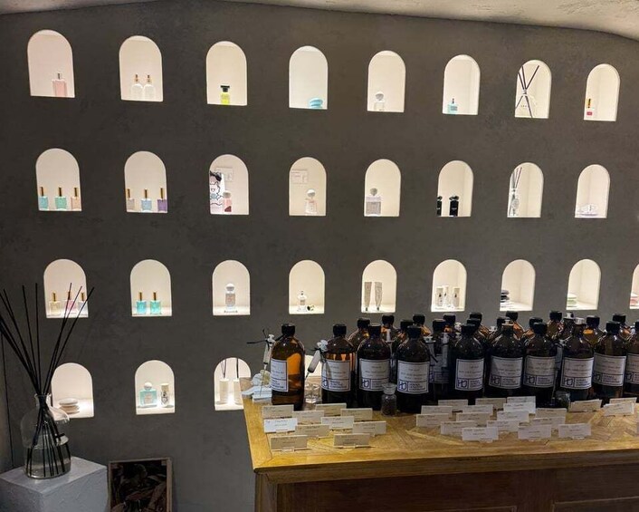 A wall with multiple arched windows displaying various bottles and labels, with a counter in the foreground. 4