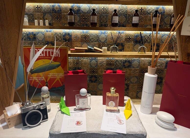 A display of perfumes and a vintage camera with a poster in the background. 3