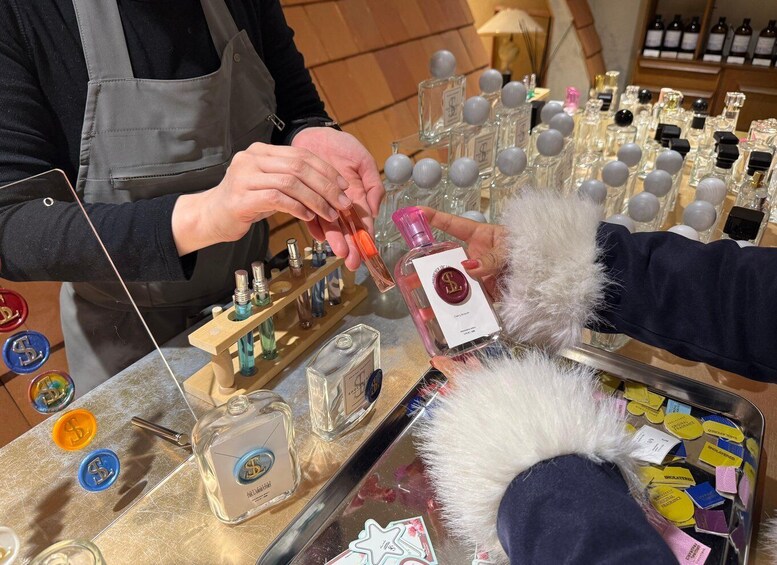 A person selecting a perfume from a display of various bottles. 1