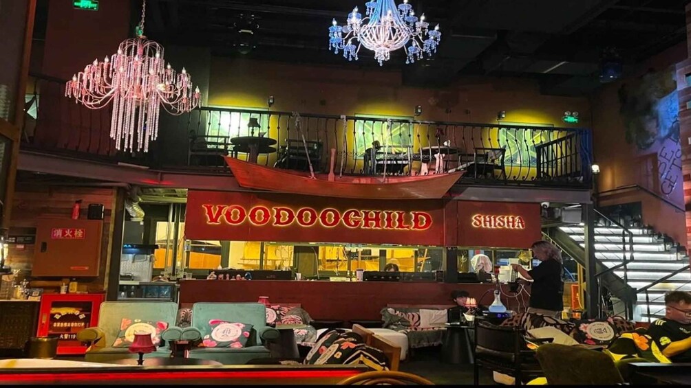 A restaurant with a red sign reading 'YOODOOCHILD' and 'SHISHA'. 3