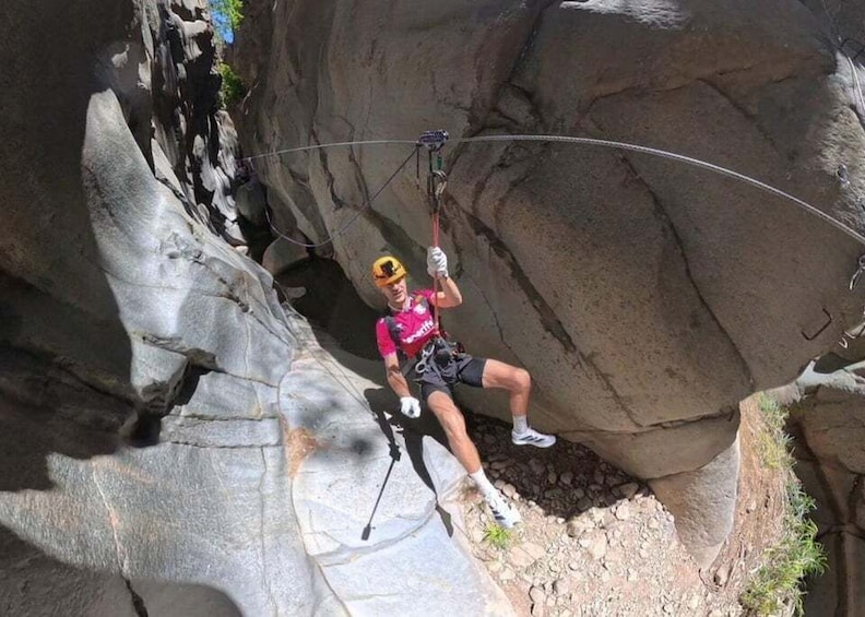 A person rappelling down a rocky cliff. 1