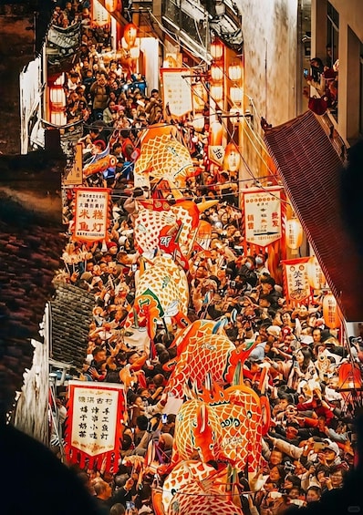 A crowded street with dragon floats and lanterns. 5
