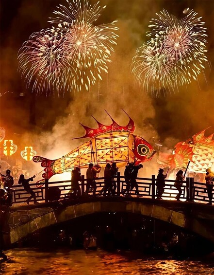 A bridge with people and a large fish-shaped lantern. 3