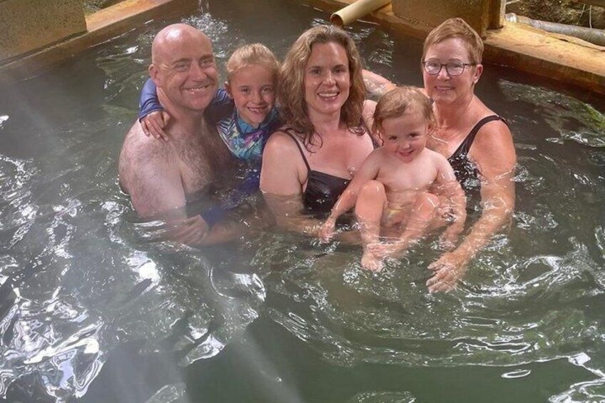 A family in a hot tub with water splashing around them. 4