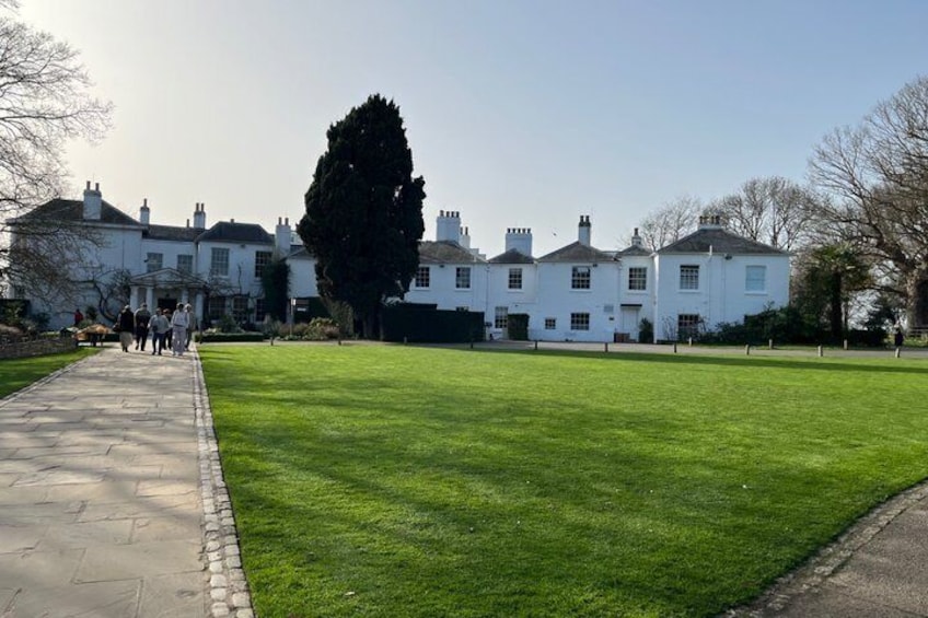 A well-maintained lawn, a pathway, and a row of white houses with chimneys. 2