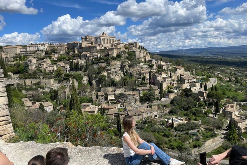 A historic town with stone buildings, a prominent church, and a hilly landscape. 1