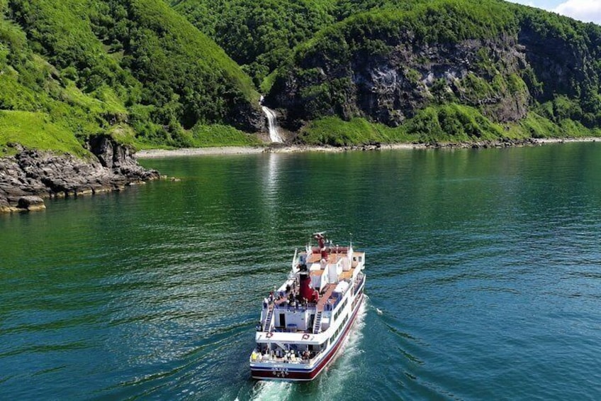 A boat on a river with a waterfall in the background. 4