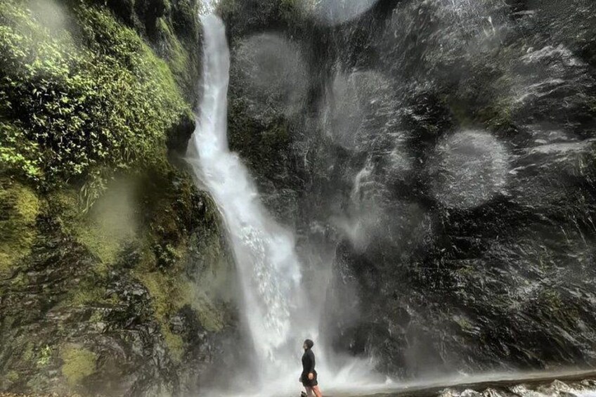 A waterfall with a person standing in front of it. 5