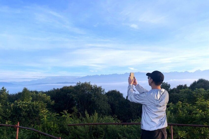 A person taking a photo of a mountainous landscape. 1