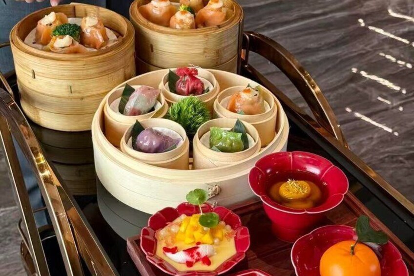 A variety of dim sum dishes in bamboo steamers and ceramic bowls, arranged on a tray. 4