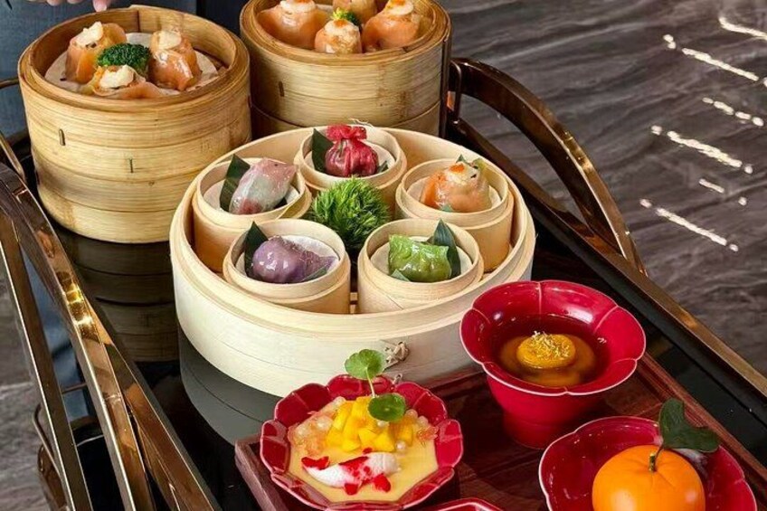 A variety of dim sum dishes in bamboo steamers and ceramic bowls on a tray. 4