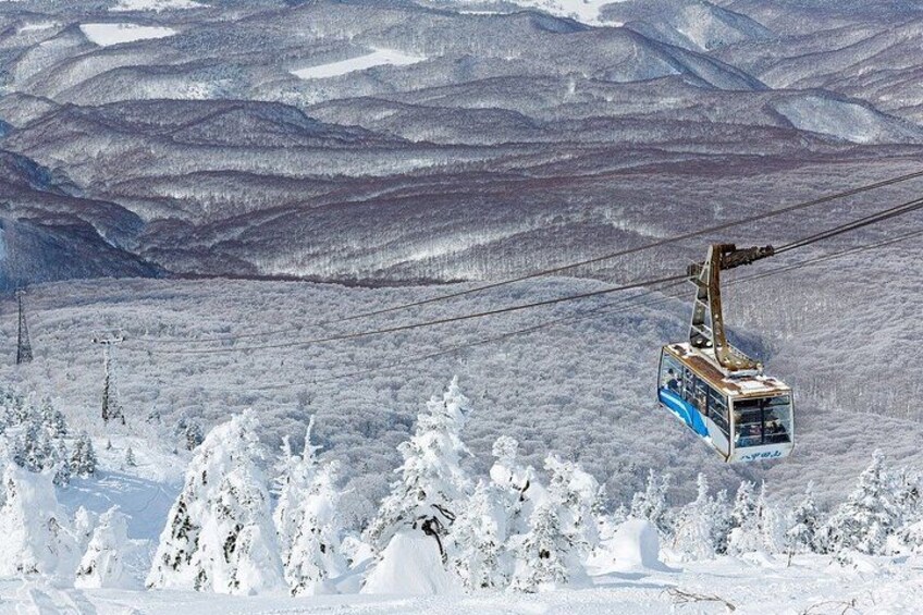 A cable car moving over a snowy mountainous landscape. 4