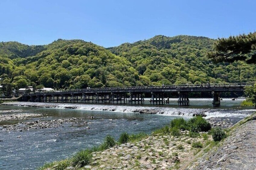 A bridge over a river with a forested hillside in the background. 3
