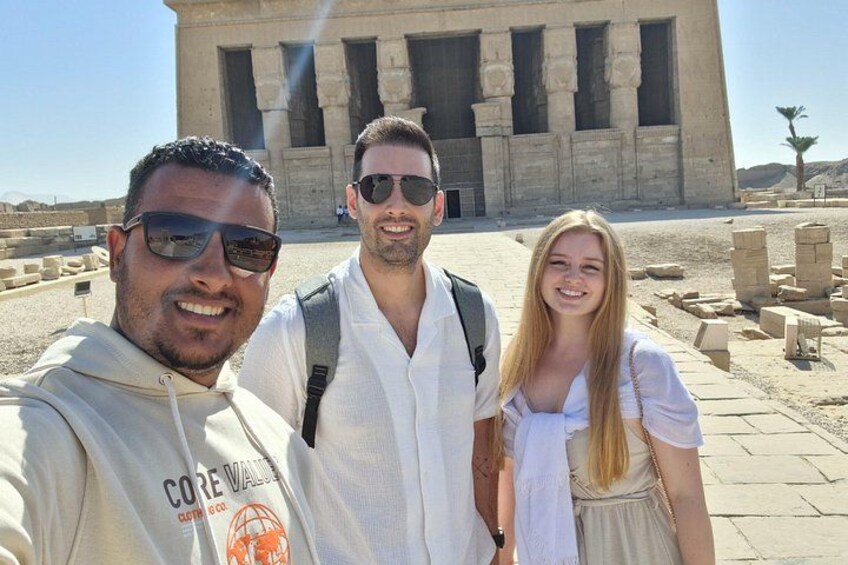 Three people standing in front of an ancient Egyptian temple with large columns. 2