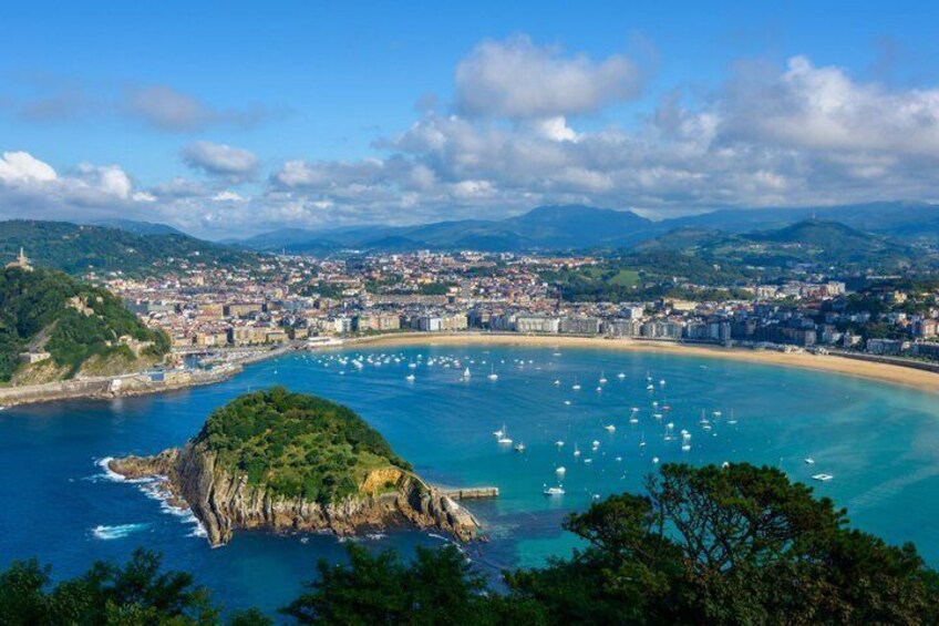 A coastal city with a bay, boats, and a prominent hill. 1