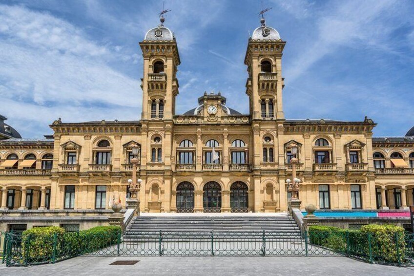 A large, historic building with two prominent towers, a central dome, and a symmetrical facade. 5