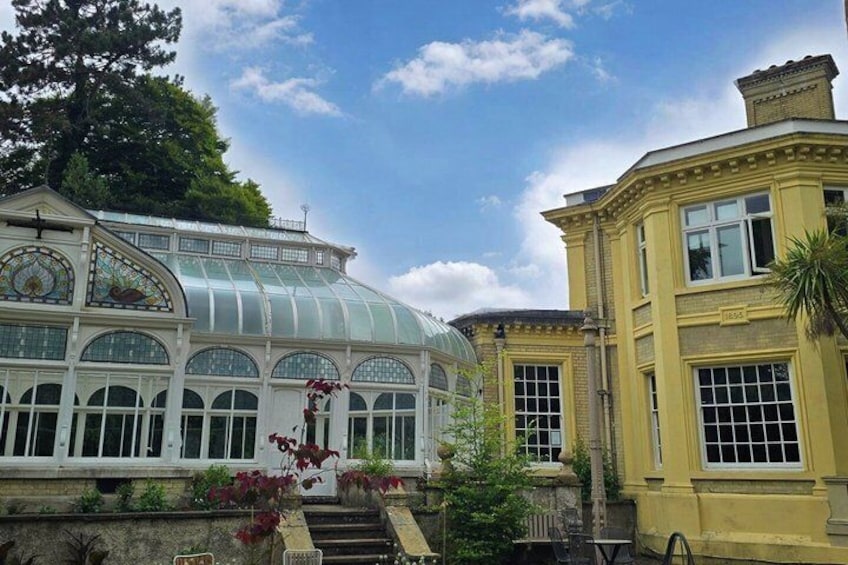 A greenhouse with a glass dome and a yellow building with large windows. 1