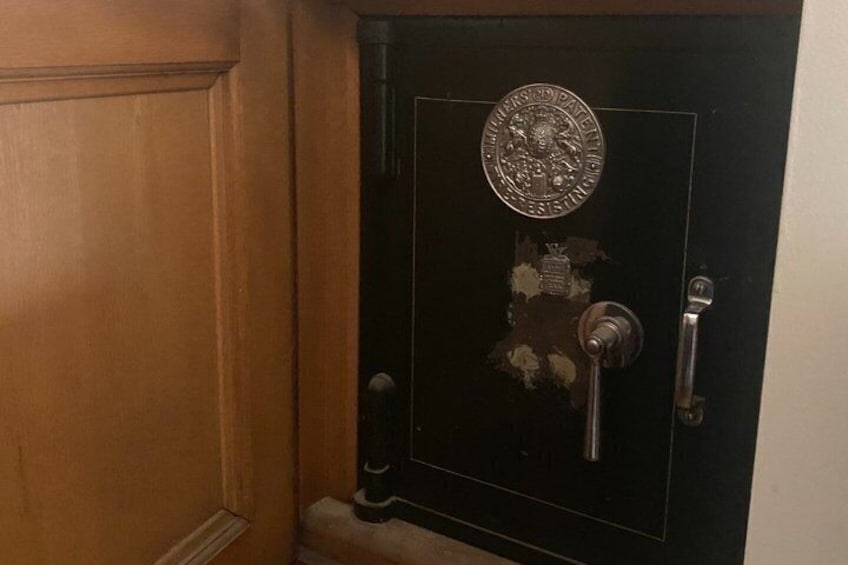 A black safe with a metallic emblem, a keyhole, and a handle. 2