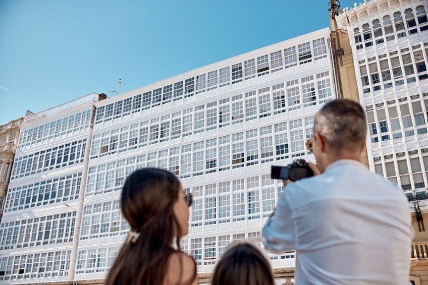 A building with large windows and a person taking a photo. 4